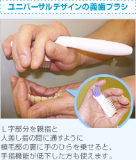 ユニバーサルデザインの義歯ブラシ：L字部分を親指と人差し指の間に通すように植毛部の裏に手のひらを乗せると、手指機能が低下した方も使えます。